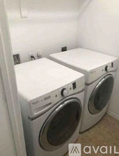 Two front loading washing machines in a small laundry room.