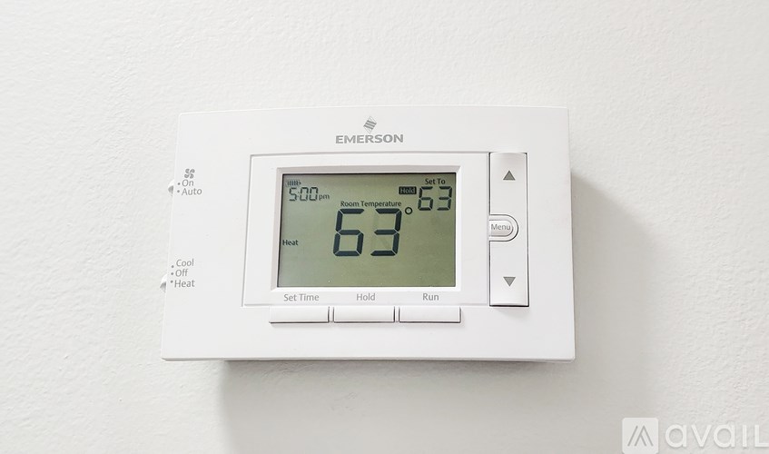 A white thermostat shows the temperature as 63 degrees.