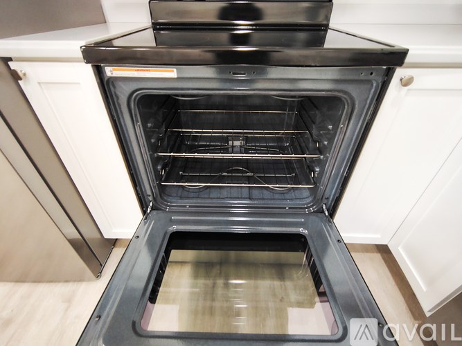 A modern black oven with the door open in a kitchen.