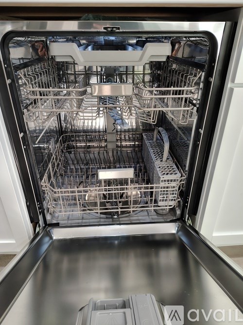 A dishwasher with the door open showing the racks inside.