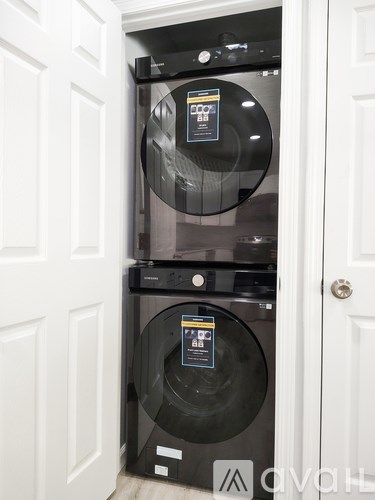 Two black front loading washing machines in a white door.