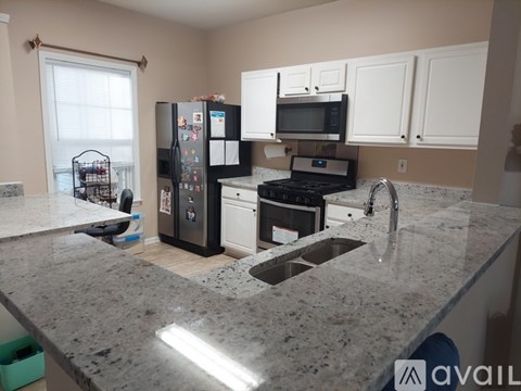 A kitchen with granite countertops and white cabinets.