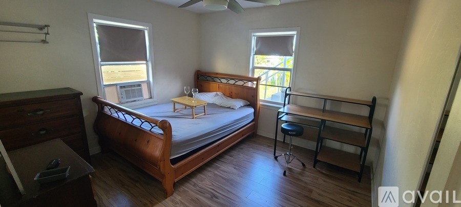 A bedroom with a bed, dresser, and window.
