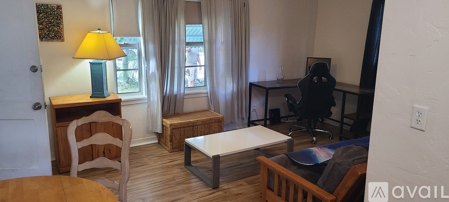 A room with a desk, chair, and window.