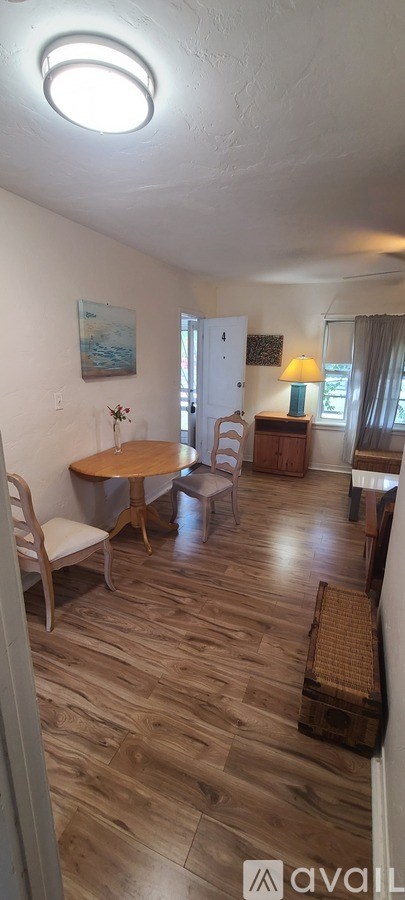 A living room with a wooden floor and a white ceiling.