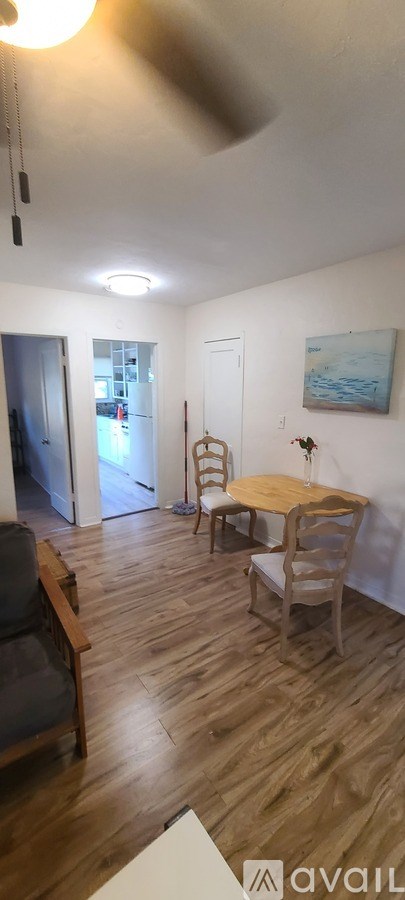 A room with a wooden floor and a table with chairs.