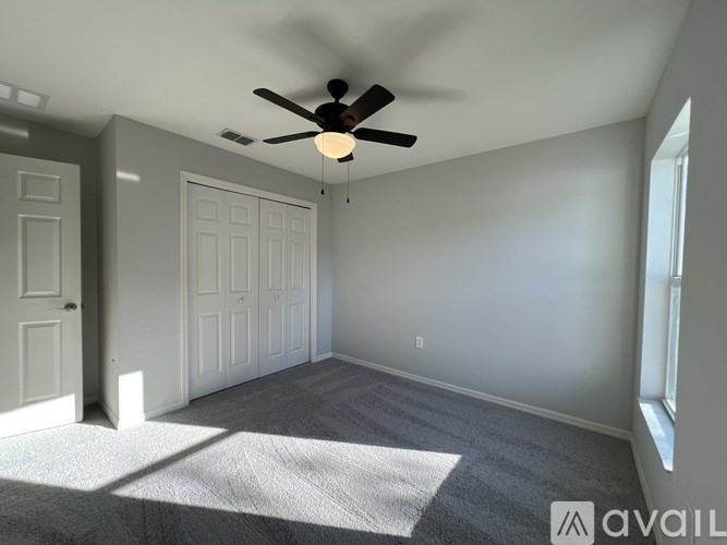 A room with a ceiling fan and two doors.