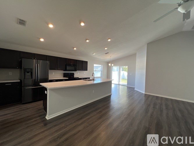A modern kitchen with dark wood floors and white countertops.