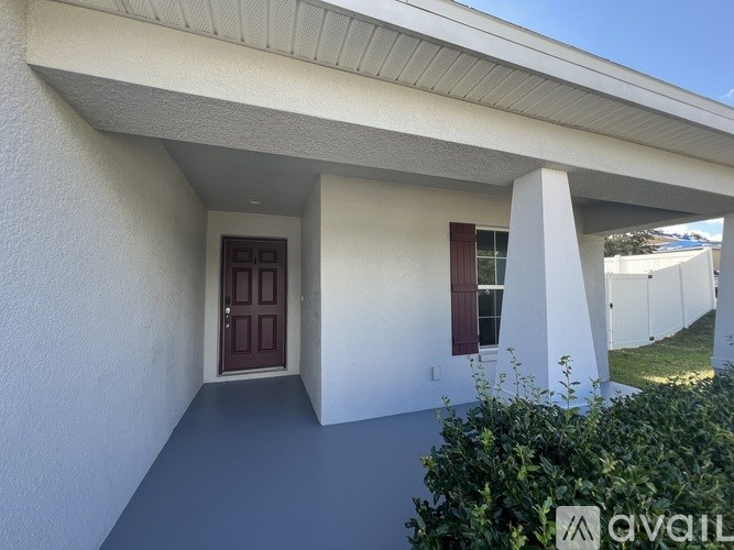 A house with a brown door and a window with a red curtain.