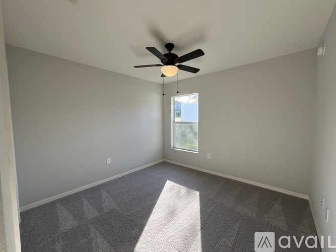 A room with a ceiling fan and a carpeted floor.