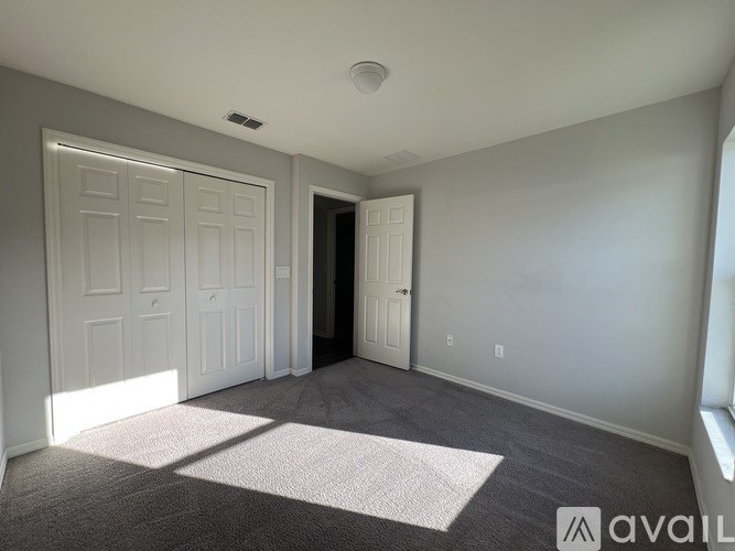 A room with a carpeted floor and two doors.