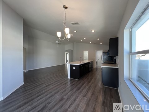 A spacious kitchen with dark wood flooring and modern appliances.