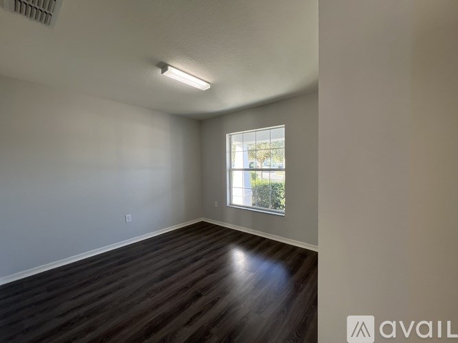 A room with wooden flooring and a window.