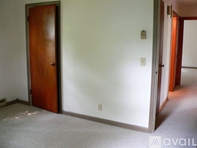 A room with a brown door and a white wall.