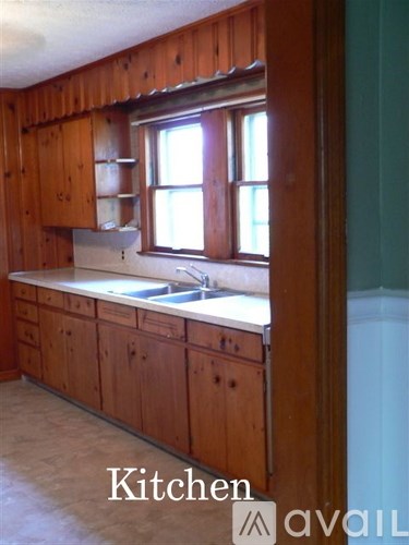 A kitchen with wooden cabinets and a window.