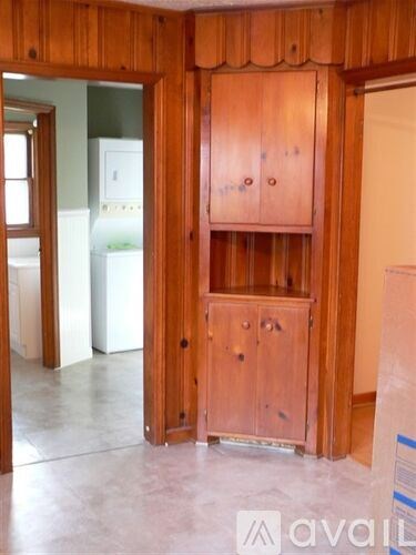 A wooden cabinet with a drawer is in the middle of a room.