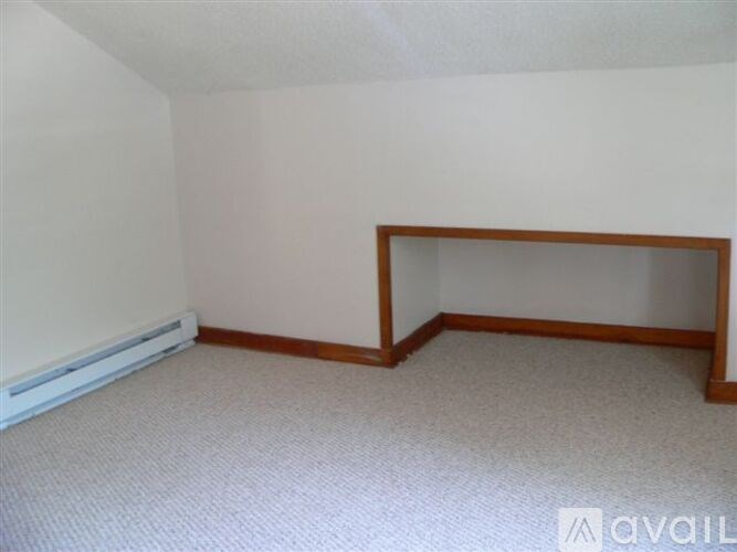 A room with a carpeted floor and a wooden frame on the wall.