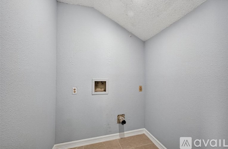 A room with a white wall and a small picture frame on it.