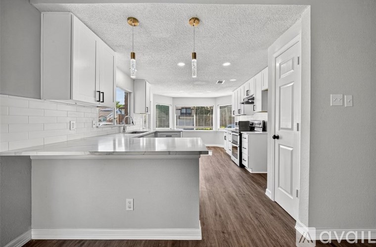 A modern kitchen with white cabinets and a large island.