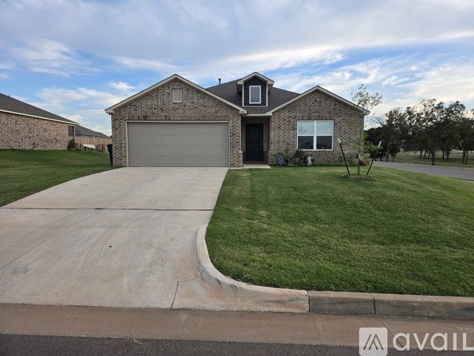 A house with a garage and a driveway in front of it.