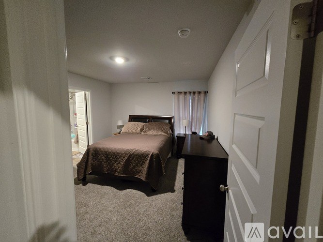 A bedroom with a bed and a dresser.