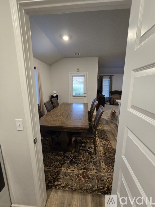 A dining room with a wooden table and chairs.