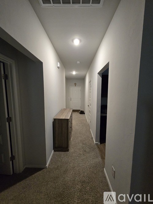 A long hallway with a bench and a door on the left.