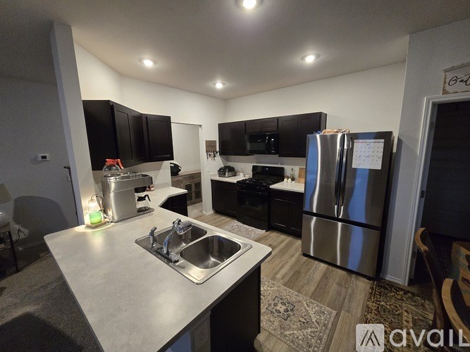 A kitchen with black cabinets and stainless steel appliances.