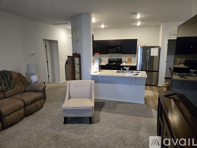 A living room with a brown couch and a white chair.