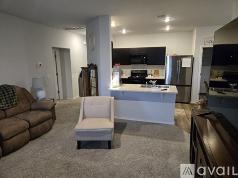 A living room with a brown couch and a white chair.