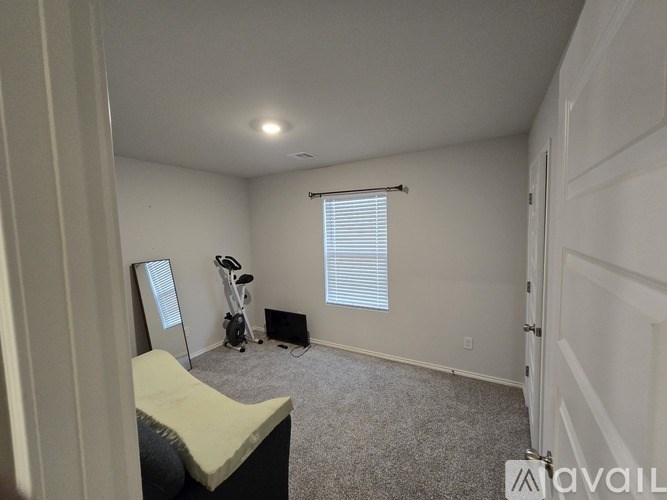 A room with a window, a vacuum cleaner, and a mattress.