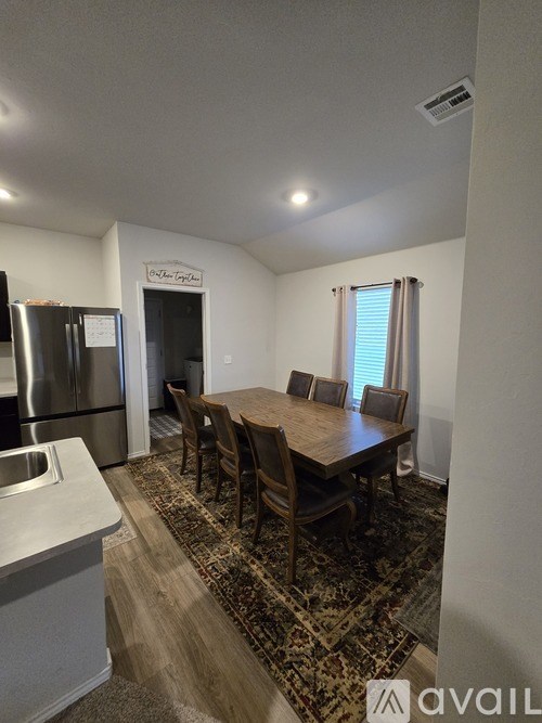 A kitchen with a dining table and chairs.