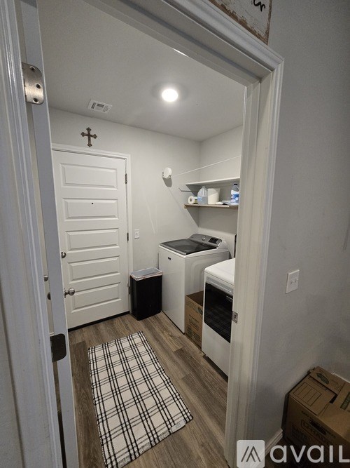 A small room with a white door and a checkered rug on the floor.
