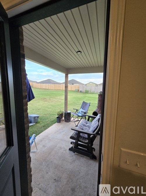 A patio with a chair and a table is visible through a doorway.