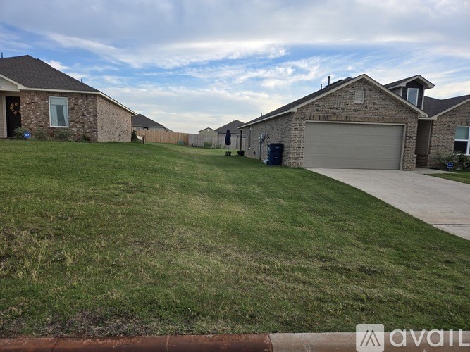 A grassy area in front of a row of houses with a sign that says "available".