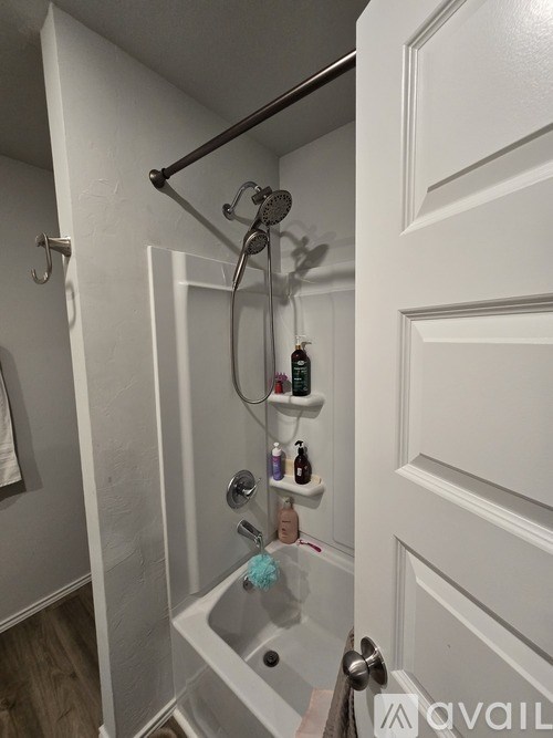 A bathroom with a white door and a shower with a glass door.