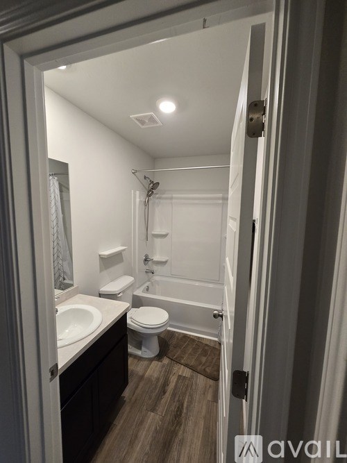 A bathroom with a toilet, sink, and bathtub.