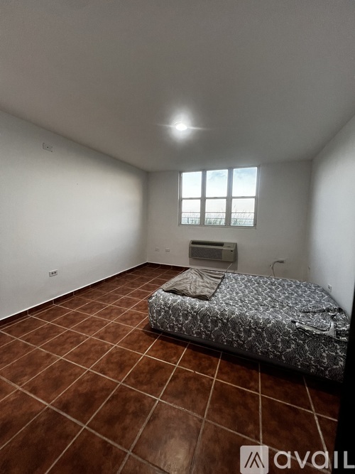 A bedroom with a bed and a window.