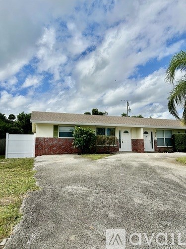 A house with a white garage door and a brick wall.