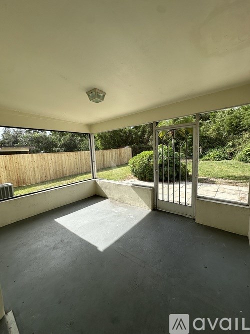 A room with a slanted ceiling and a glass door leading to a backyard.