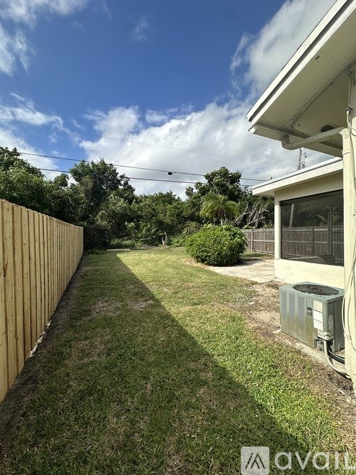 A backyard with a wooden fence and a utility box.