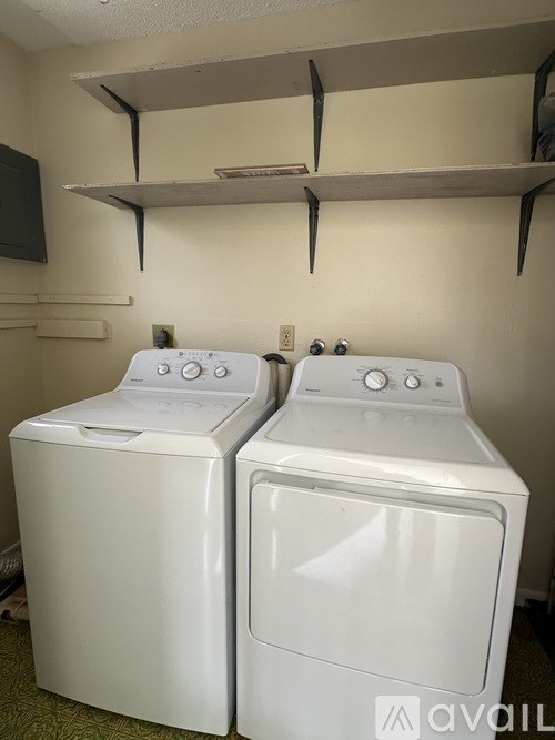 Two white front loading washing machines in a laundry room.