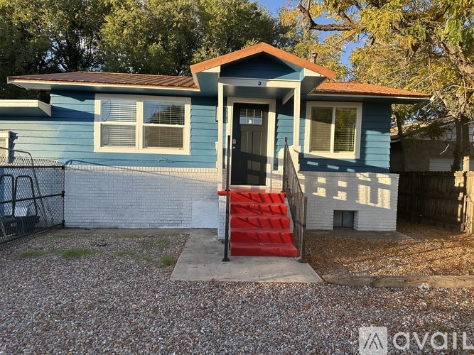 A blue house with a red staircase leading to the front door.