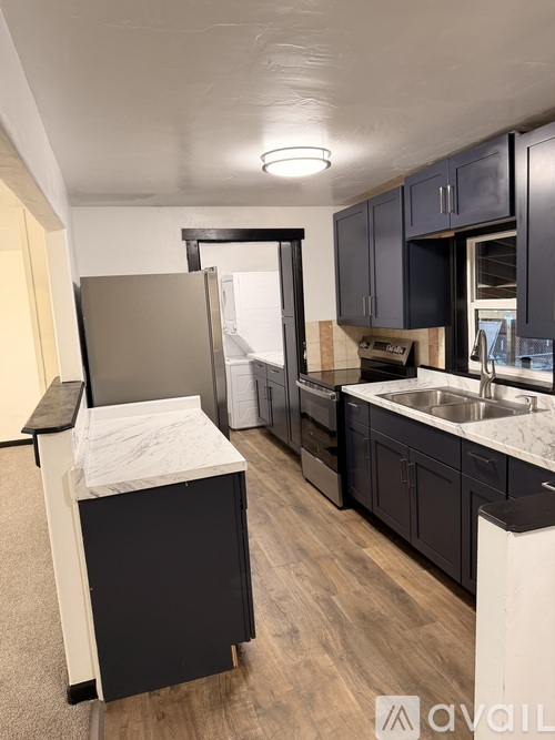 A kitchen with black cabinets and a white countertop.