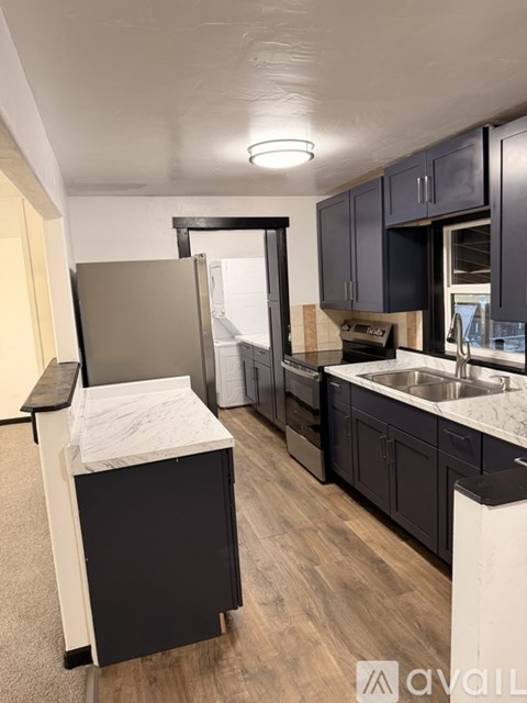 A kitchen with black cabinets and a white countertop.