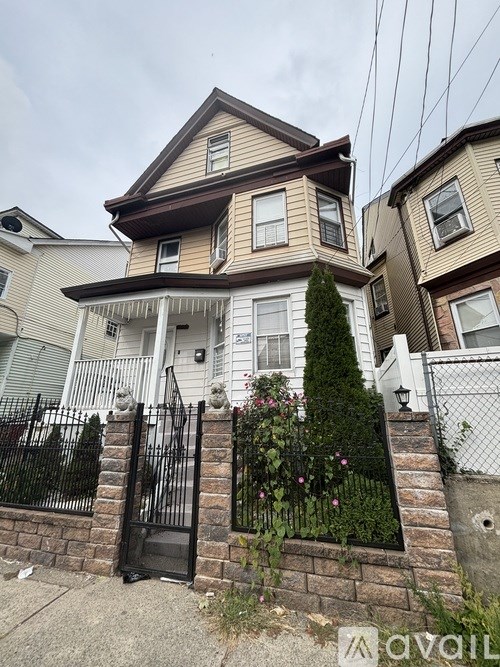 A house with a black gate and a brick wall.