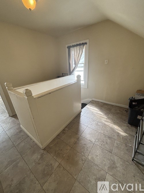 A room with a window and a tiled floor.