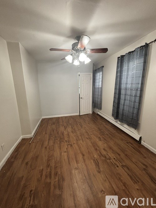 A room with wooden floors and a ceiling fan.