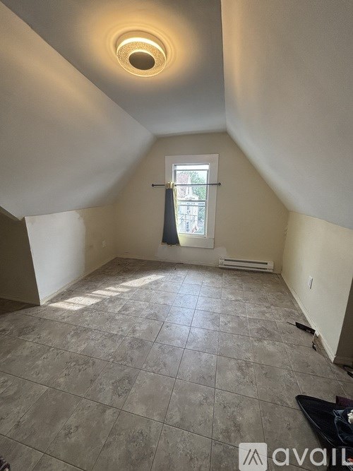 A room with a tiled floor and a window with a view of a building outside.