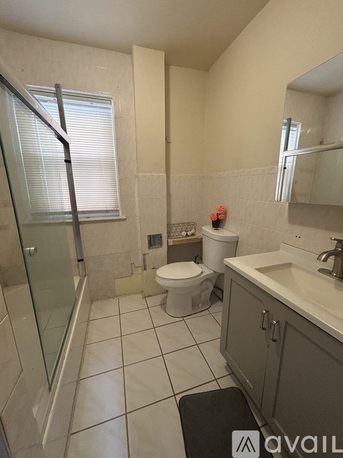 A bathroom with a toilet, sink, and shower.